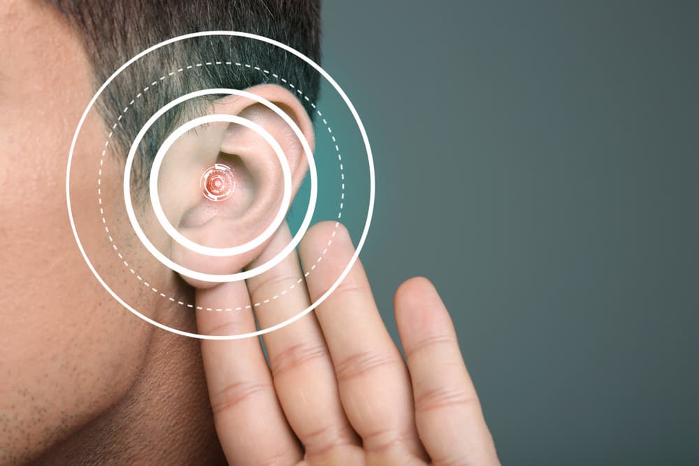 Photo of person trying to hear better by folding their ear.